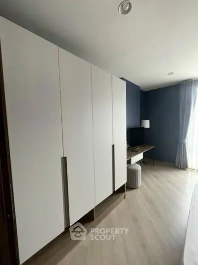 Modern bedroom with sleek wardrobe and natural light