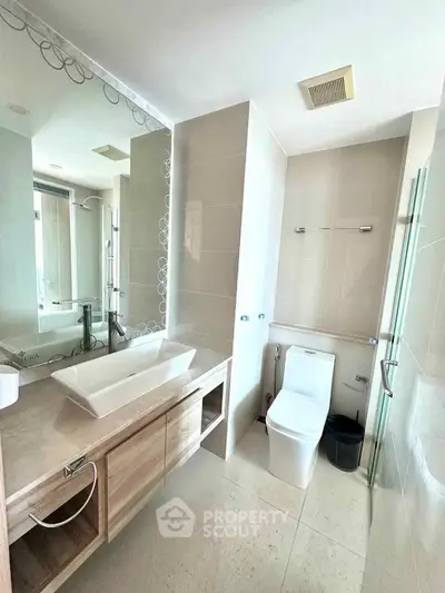 Modern bathroom with sleek fixtures and large mirror in a contemporary apartment.