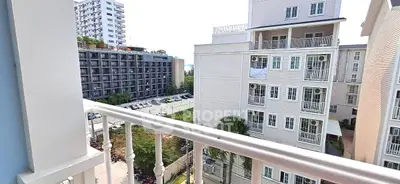 Charming balcony view of modern apartment complex with lush greenery and urban surroundings.