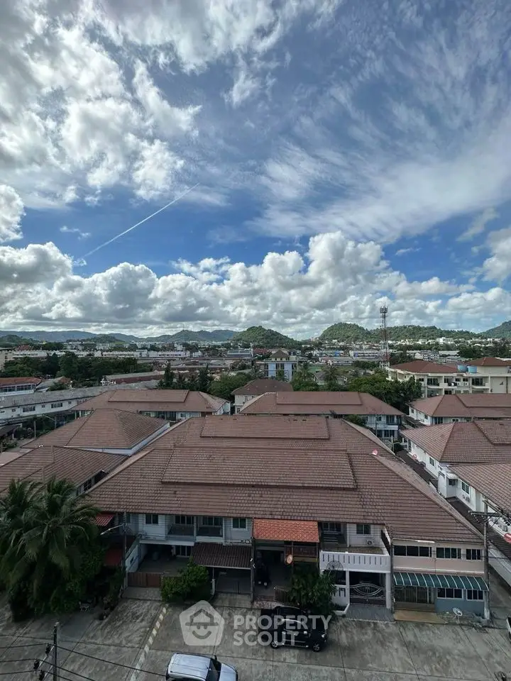 Scenic aerial view of residential neighborhood with mountains and blue sky backdrop.