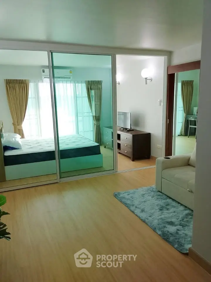 Modern apartment interior with cozy living room and bedroom separated by glass doors, featuring stylish decor.