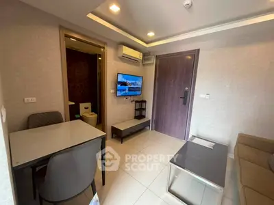 Modern living room with sleek furniture and wall-mounted TV in a cozy apartment.
