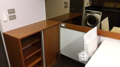 Modern interior with built-in wooden shelves and washing machine in compact space