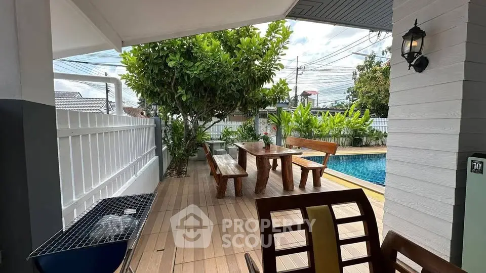 Charming outdoor patio with wooden dining set and pool, perfect for entertaining and relaxation.