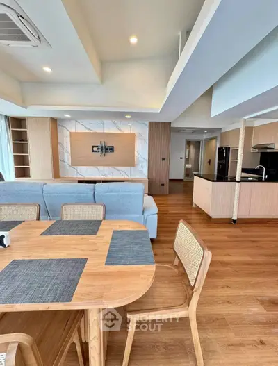 Spacious modern living room with open kitchen and stylish wooden furniture