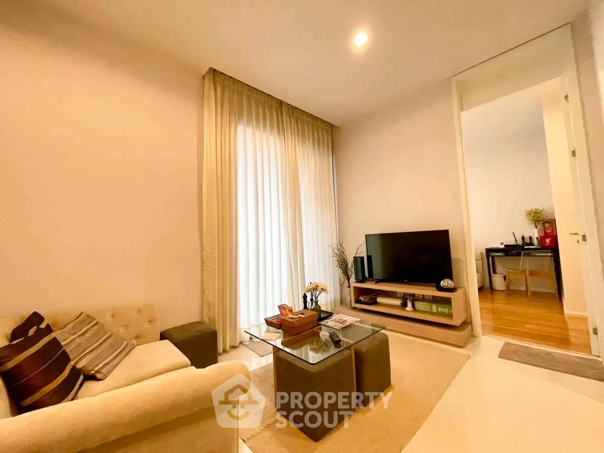 Cozy living room with modern decor and natural light, featuring a comfortable sofa and entertainment unit.