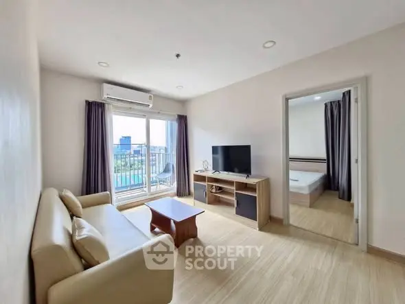 Modern living room with balcony view and adjacent bedroom in a stylish apartment.