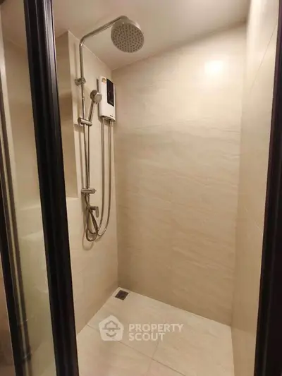Modern shower area with sleek fixtures and neutral tiles in a contemporary bathroom.