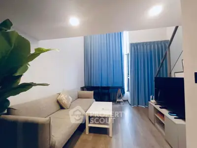 Modern living room with high ceiling and stylish decor in a contemporary apartment.