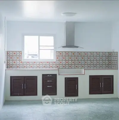 Spacious kitchen with vintage tile backsplash and modern range hood, perfect for culinary enthusiasts.