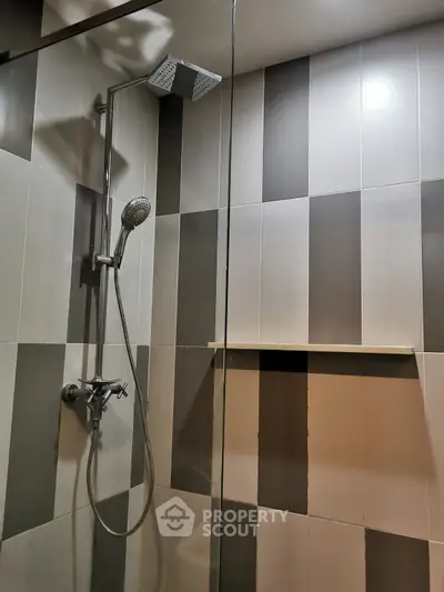Modern bathroom with sleek showerhead and stylish striped tiles