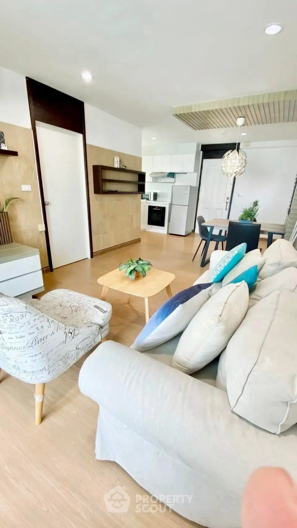 Modern open-plan living room with cozy seating and stylish kitchen area.