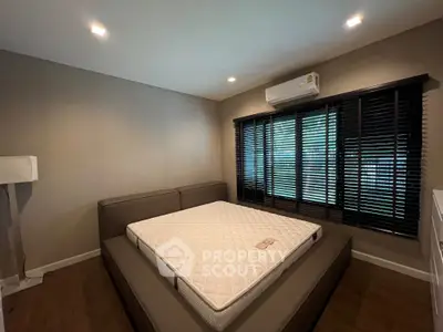 Spacious bedroom with modern design and large windows for natural light.
