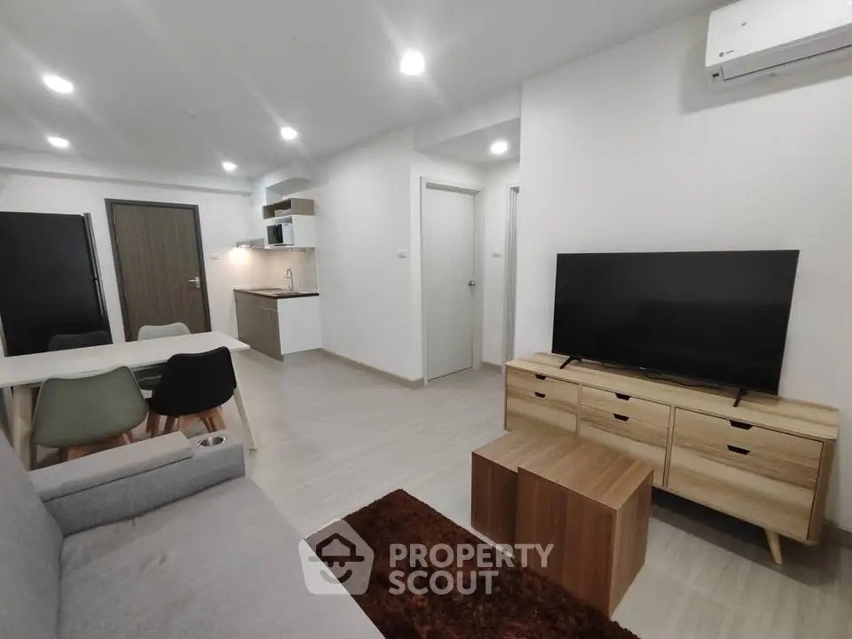 Modern living room with sleek furniture and open kitchen layout in a stylish apartment.