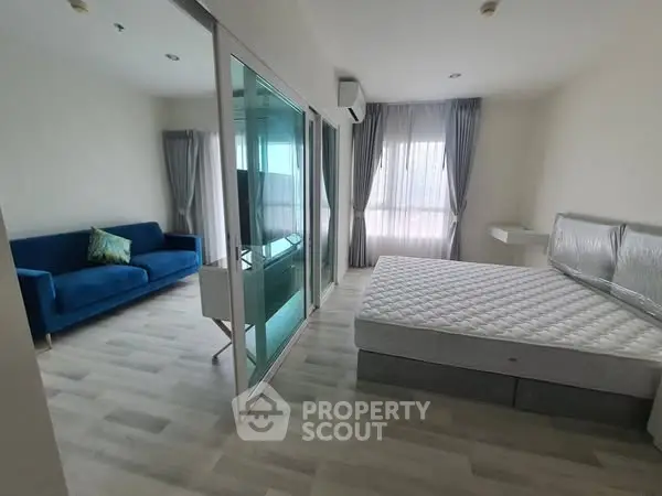 Modern bedroom with glass partition and stylish blue sofa
