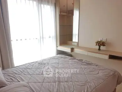 Cozy bedroom with natural light and modern furnishings in a stylish apartment.