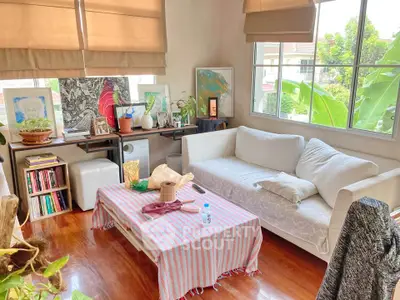 Charming living room with cozy white sofa and vibrant decor, perfect for relaxation and creativity.