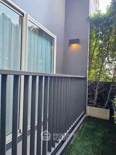 Charming balcony with modern railing and lush greenery, perfect for relaxation and outdoor enjoyment.
