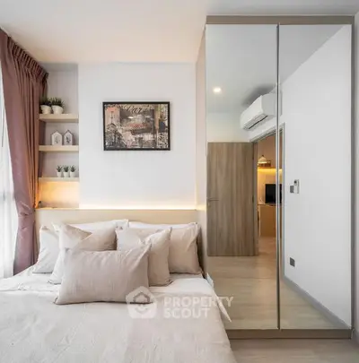 Modern bedroom with mirrored wardrobe and cozy decor in a stylish apartment.