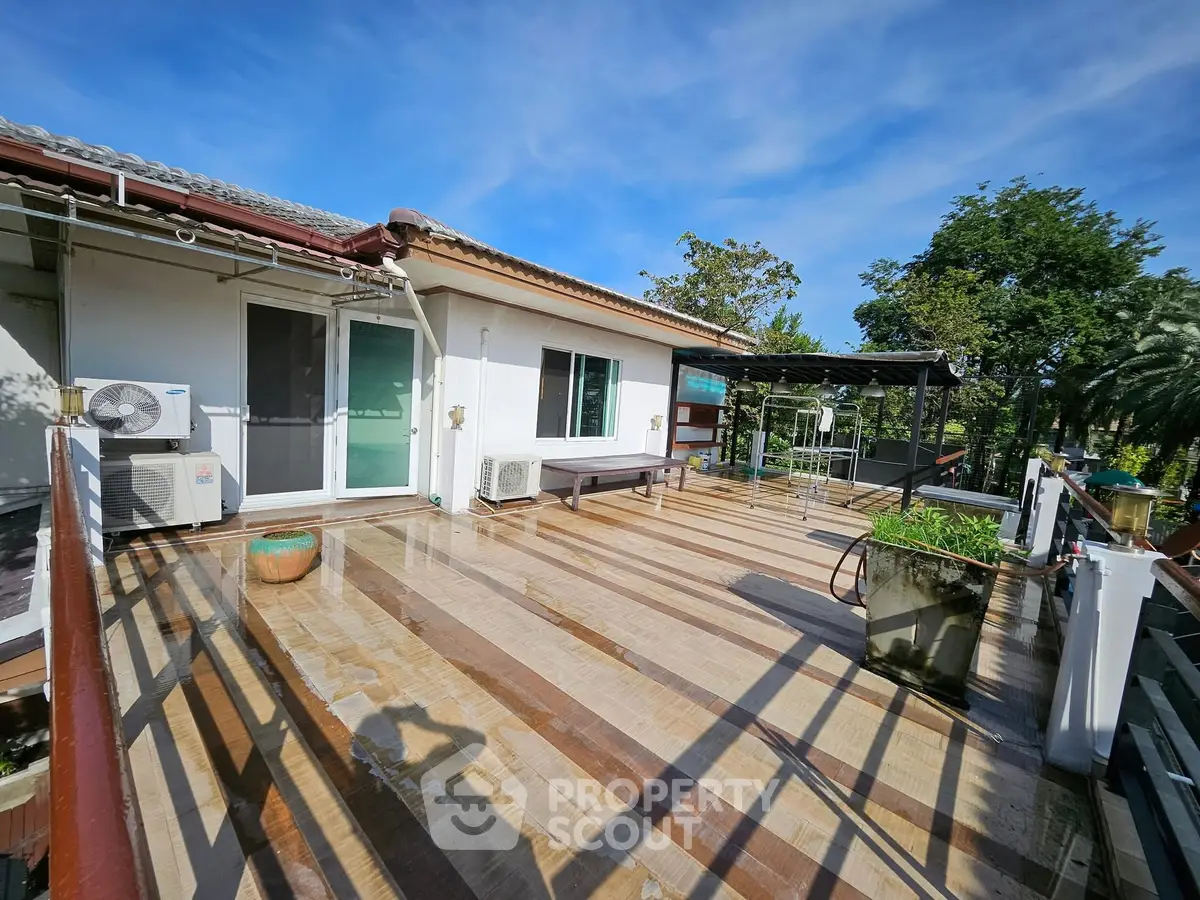 Spacious rooftop terrace with modern design and lush greenery views