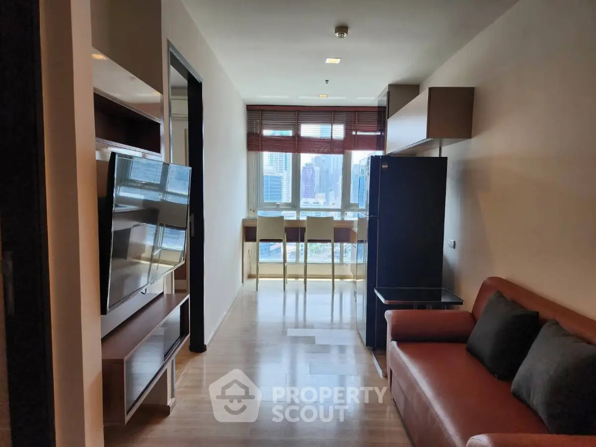 Modern living room with city view, featuring sleek furniture and large TV, perfect for urban living.