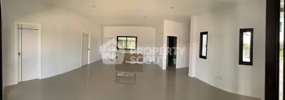 Spacious open-plan interior with modern minimalist design and large windows.