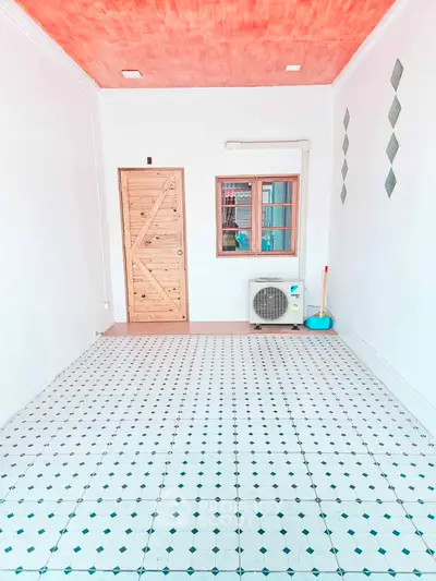 Bright room with patterned tile floor, wooden door, and air conditioning unit, ideal for versatile use.