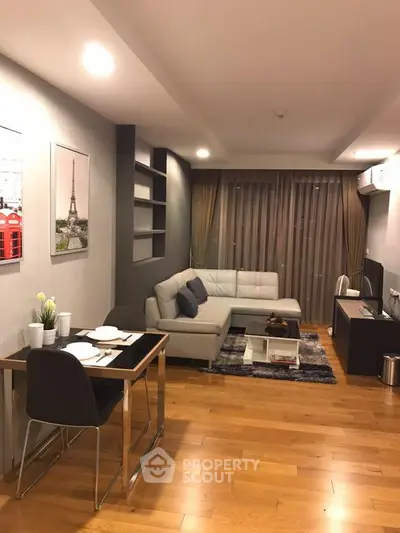 Modern living room with wooden flooring, cozy sofa, and elegant decor in a stylish apartment.