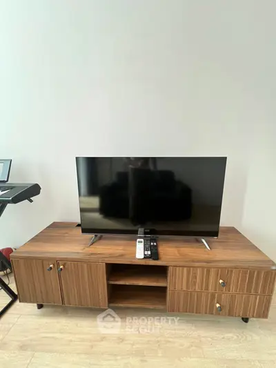 Modern living room with sleek TV stand and flat-screen TV, perfect for entertainment.