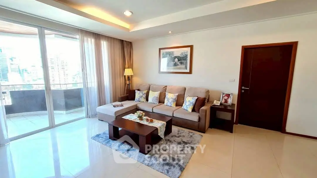 Spacious living room with modern decor and balcony view in urban apartment.