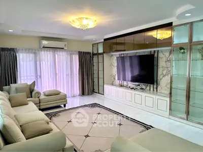 Luxurious living room with elegant decor, large TV, and plush seating in a modern home.