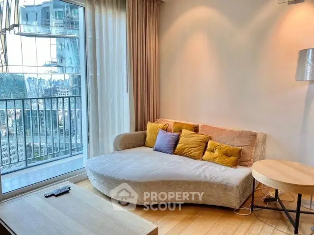 Modern living room with cozy sofa and city view from large window balcony.