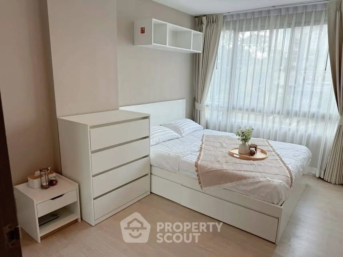 Bright and cozy bedroom with modern white furniture and large window