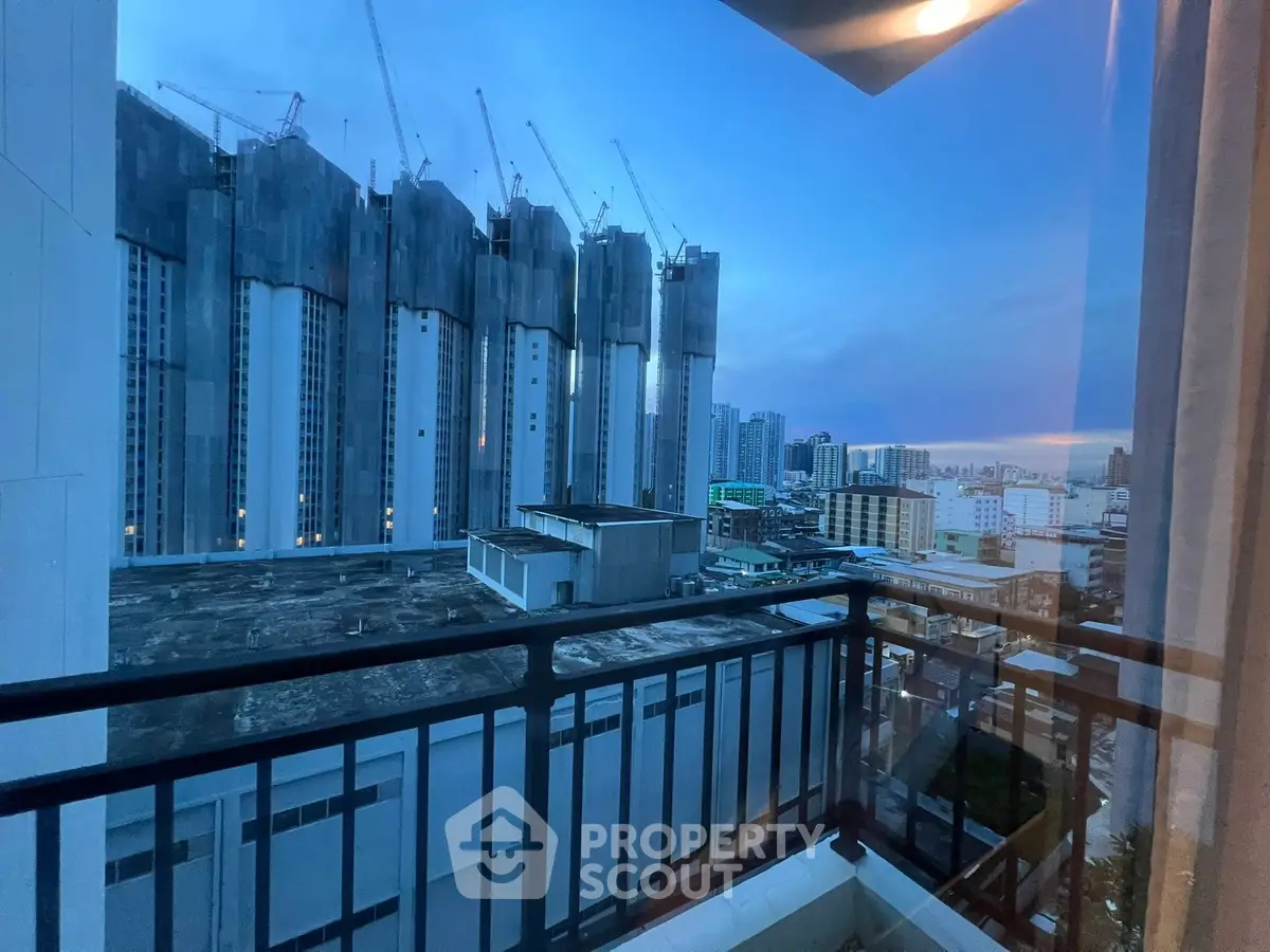 Stunning cityscape view from a modern balcony at dusk, showcasing urban high-rise buildings.