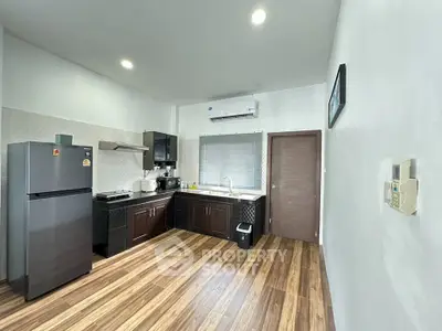 Modern kitchen with sleek appliances and wooden flooring