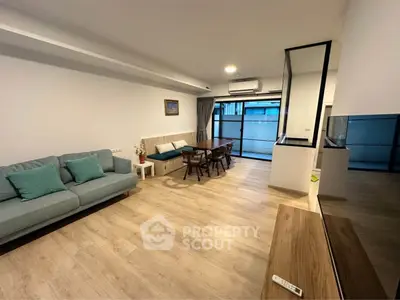 Spacious modern living room with wooden flooring and stylish furniture in a contemporary apartment.