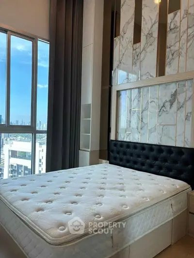 Luxurious bedroom with stunning city view and elegant marble accent wall