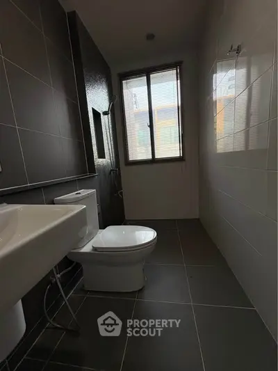 Modern bathroom with sleek design and natural light from window.