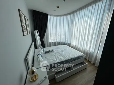 Modern bedroom with large windows and stylish decor in a high-rise apartment.