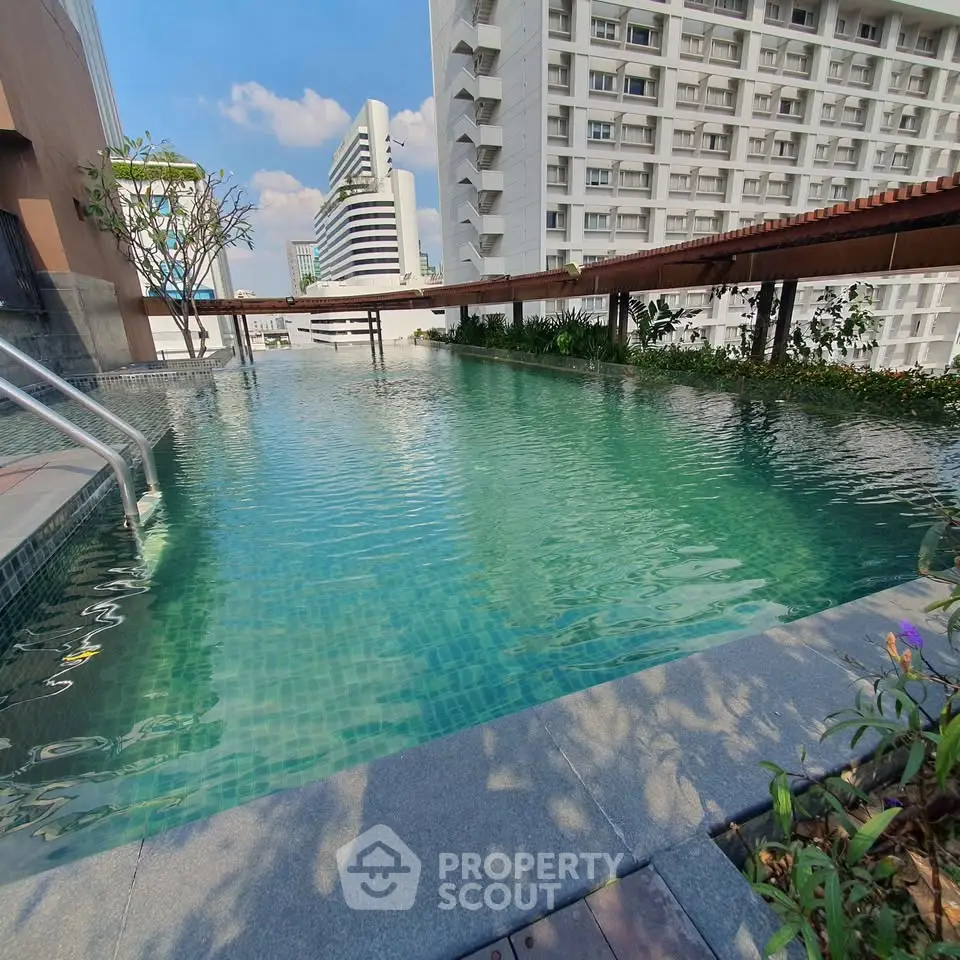 Stunning rooftop pool with cityscape views in modern residential complex.