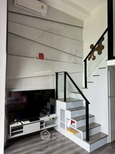 Modern living room with stylish staircase and sleek TV setup