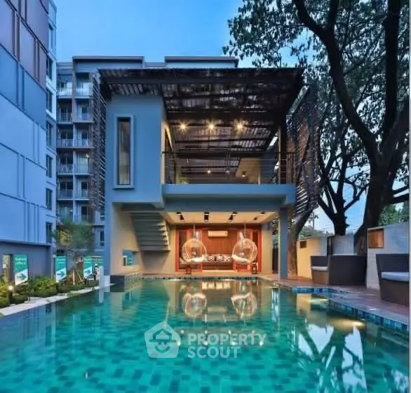 Luxurious modern building with stunning pool and stylish outdoor seating area.