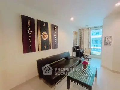 Modern living room with stylish decor and large window offering natural light.