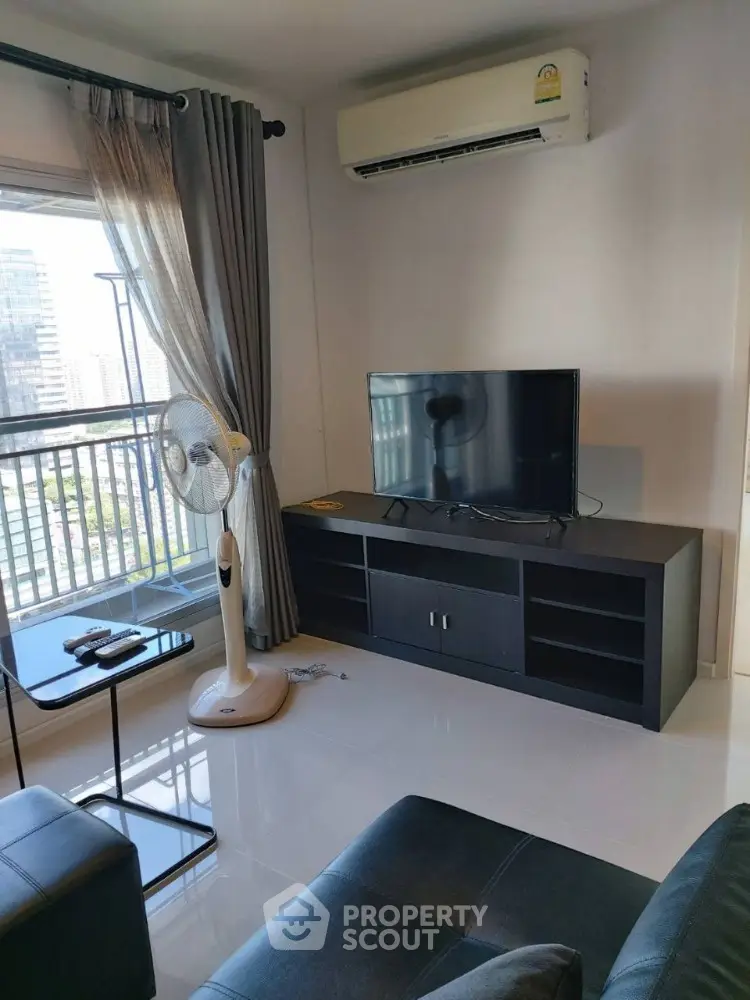 Modern living room with city view, sleek furniture, and air conditioning.