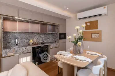 Modern kitchen with sleek design, featuring a washing machine, dining table, and elegant decor.