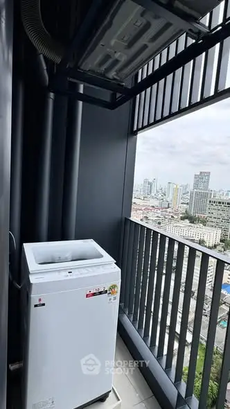 High-rise balcony with washing machine and city skyline view