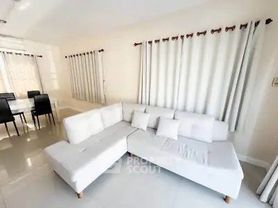 Spacious living room with modern white sectional sofa and dining area