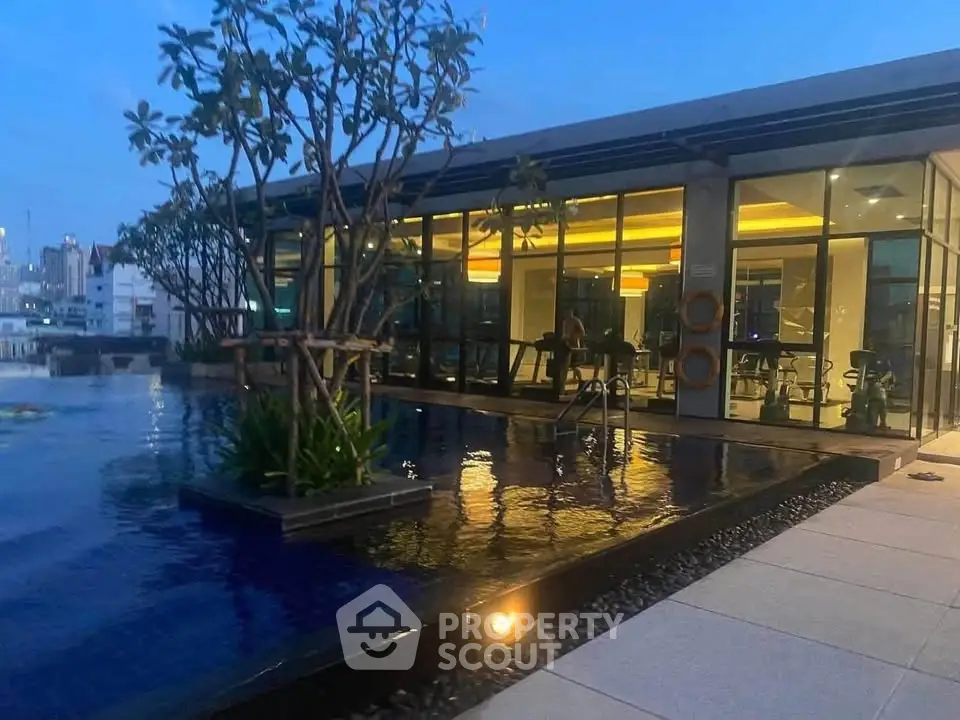 Luxurious rooftop pool with modern glass building and city view at dusk.