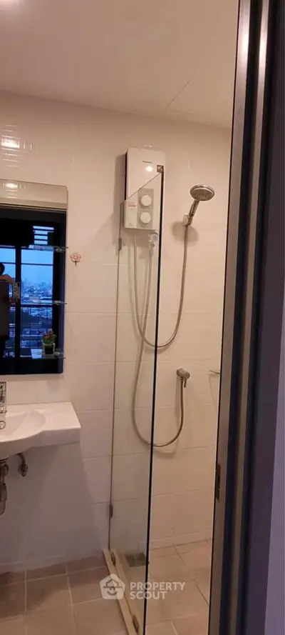 Modern bathroom with glass shower enclosure and sleek fixtures in a contemporary apartment.