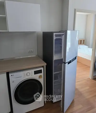 Modern apartment with kitchen appliances and glimpse of cozy bedroom